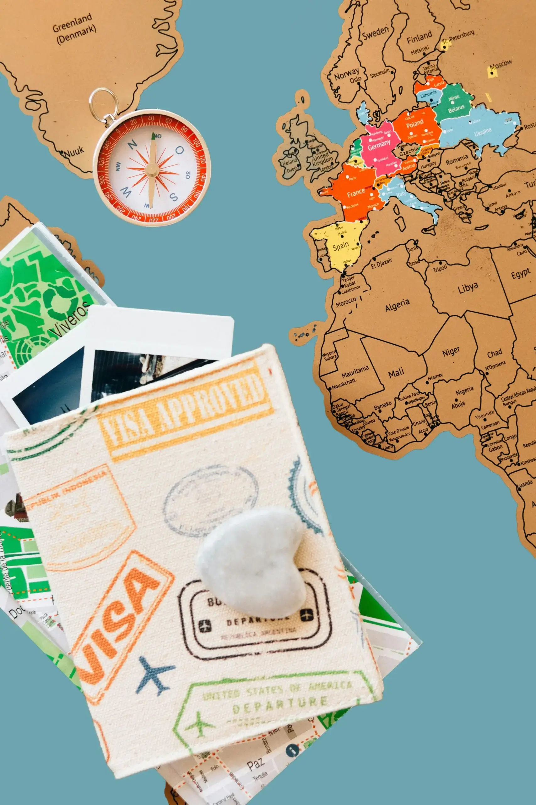 Travel-themed arrangement with map, compass, photographs, and passport